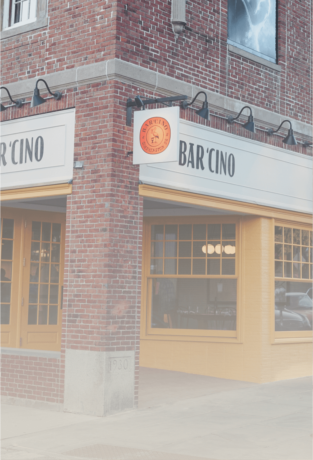 Exterior of brick building with yellow walls and Bar Cino in large black letters