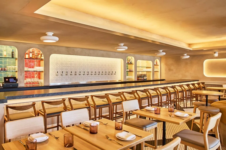 Baleia’s dining room with warm lighting and a long marble bar